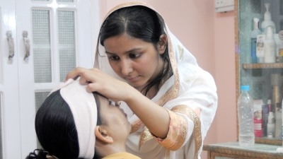 Sufia Aslam works in the two-seat beauty shop she started with the help of a loan from the Pakistan Poverty Alleviation Fund. Muzammil Pasha/World Bank